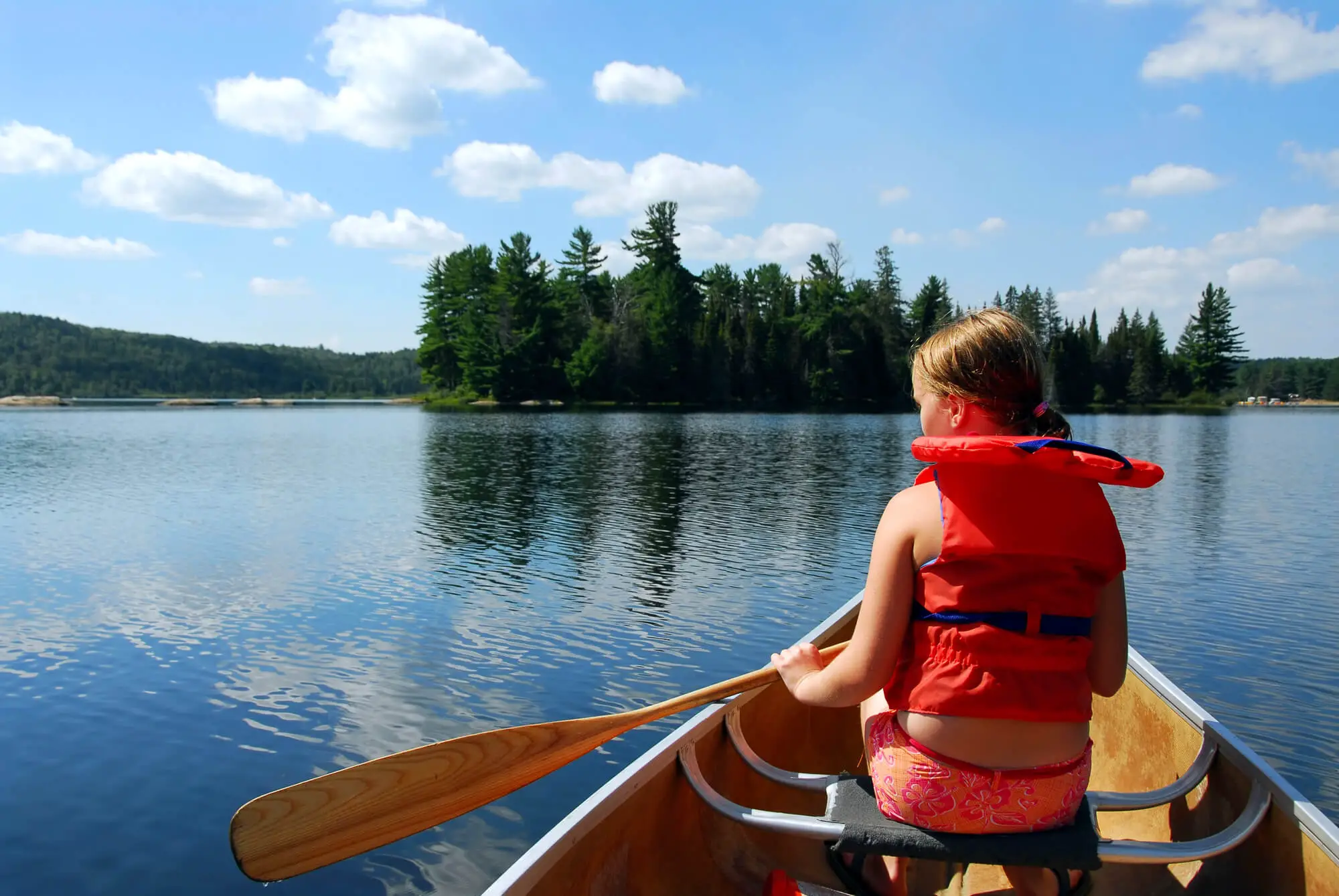 child paddling on lake